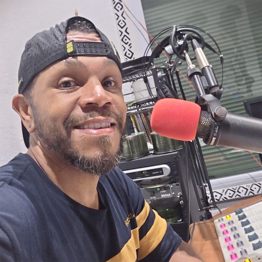 DJ A Plus on the mic in the Black Power 96 Radio studio